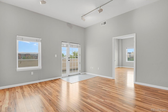 1780 N Washington St Unit 405, Denver, CO 80203 - empty room with rail lighting, light wood-style floors, a towering ceiling, and baseboards