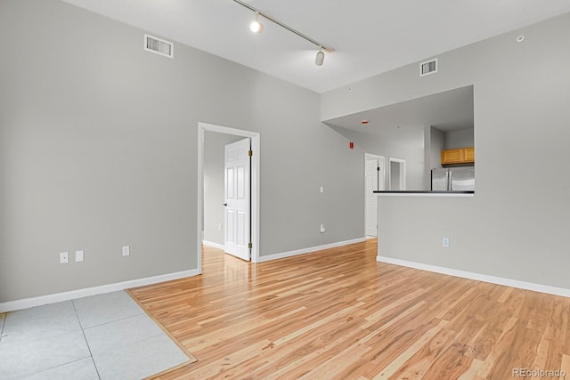 1780 N Washington St Unit 405, Denver, CO 80203 - unfurnished living room with rail lighting, light wood-type flooring, and baseboards