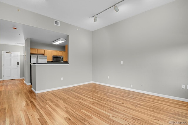 1780 N Washington St Unit 405, Denver, CO 80203 - unfurnished living room featuring track lighting, light wood-type flooring, and baseboards