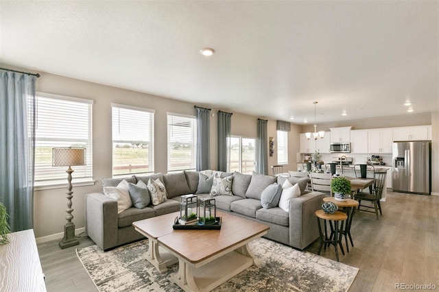 living room with an inviting chandelier and light hardwood / wood-style flooring