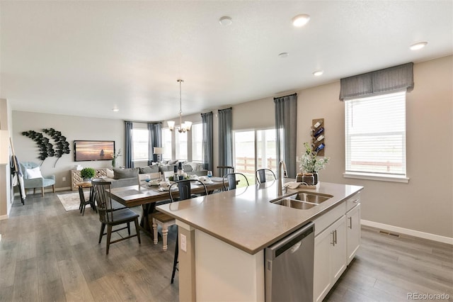 kitchen featuring sink, white cabinets, an island with sink, and stainless steel dishwasher