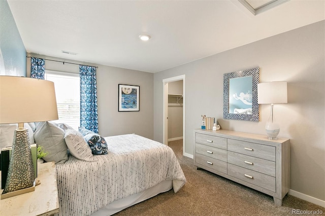 carpeted bedroom featuring a spacious closet and a closet