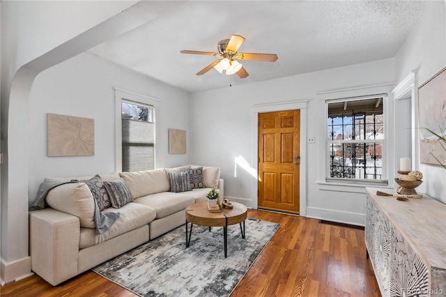 living room with hardwood / wood-style floors, ceiling fan, a wealth of natural light, and a textured ceiling