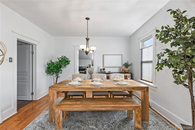 dining area with dark hardwood / wood-style flooring, a textured ceiling, and a chandelier