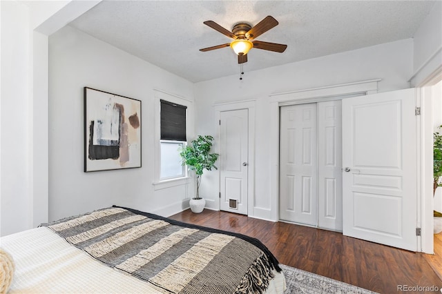 bedroom with ceiling fan, dark hardwood / wood-style floors, and a textured ceiling