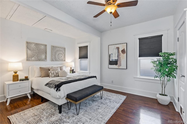 bedroom featuring dark wood-type flooring, a textured ceiling, and ceiling fan