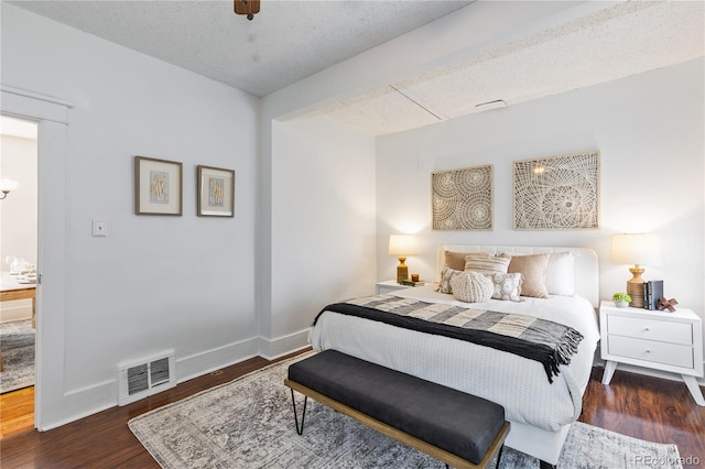 bedroom with dark wood-type flooring and a textured ceiling