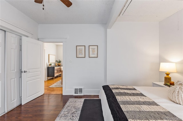 bedroom featuring dark wood-type flooring, a closet, and ceiling fan