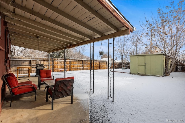 snow covered patio with an outdoor hangout area and a shed