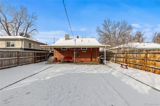 view of snow covered back of property