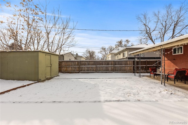 yard covered in snow with a storage unit