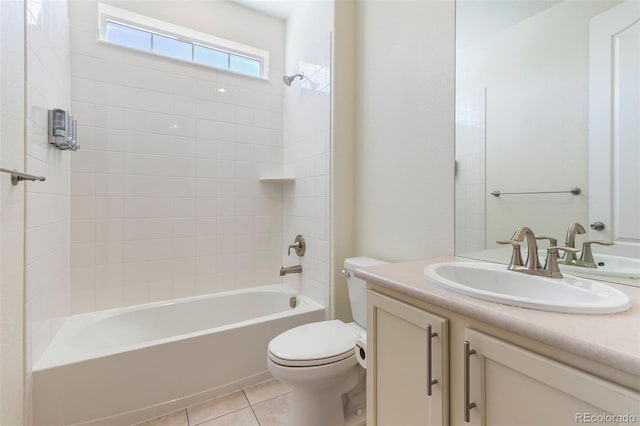 full bathroom with tile patterned flooring, toilet, tiled shower / bath, and vanity