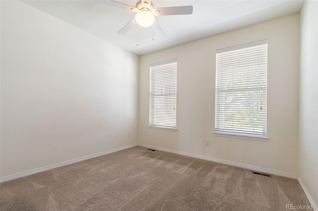 carpeted spare room with ceiling fan