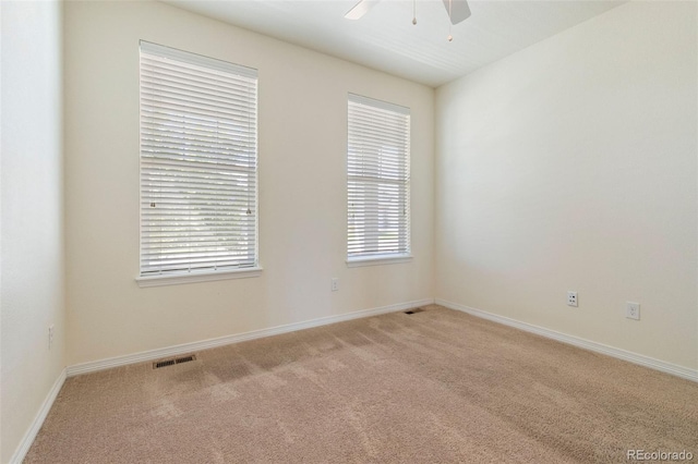 unfurnished room with ceiling fan and light colored carpet