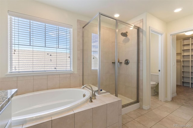 bathroom with tile patterned flooring, plenty of natural light, toilet, and separate shower and tub