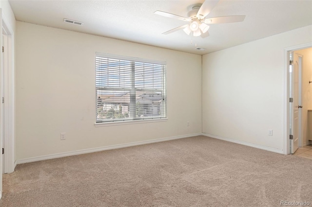 spare room featuring ceiling fan and light colored carpet