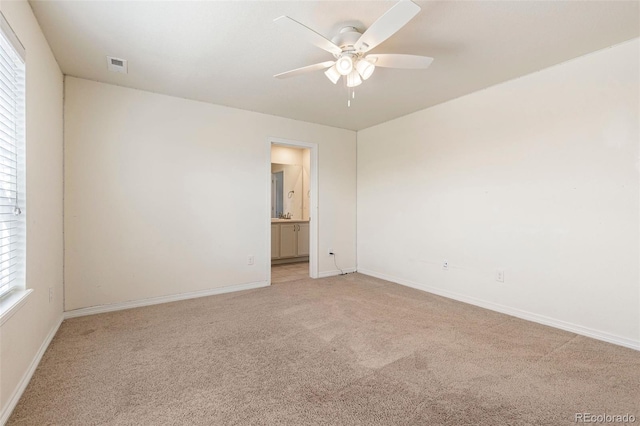 carpeted spare room featuring a wealth of natural light and ceiling fan