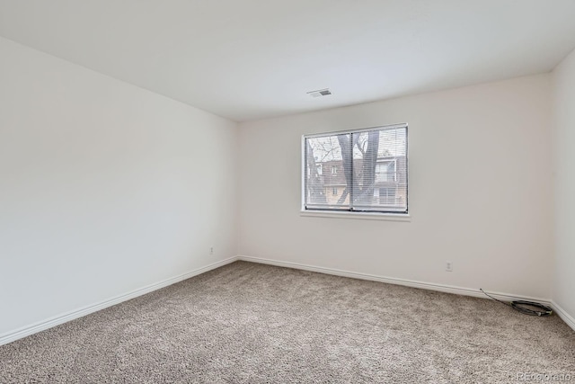 unfurnished room with baseboards, carpet flooring, and visible vents