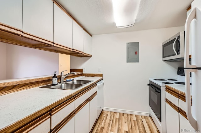 kitchen featuring a sink, electric panel, white appliances, and white cabinets
