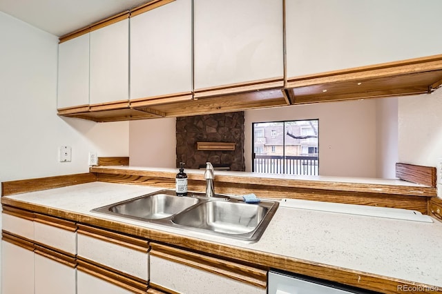 kitchen featuring a sink, light countertops, and white cabinets