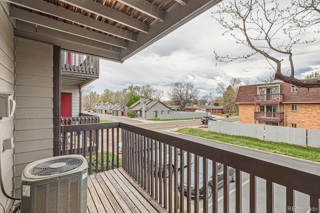 wooden deck featuring central AC unit and a residential view