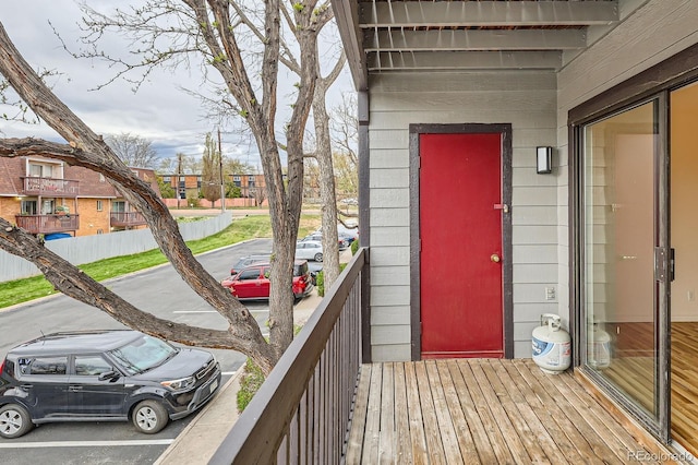 view of exterior entry with a residential view and a balcony