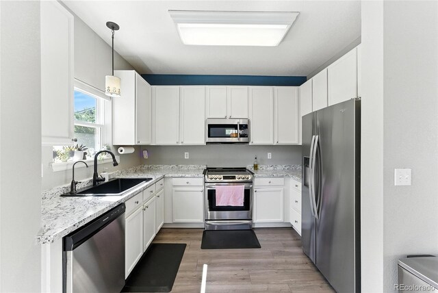 10116 Wyandott Cir, Denver, CO 80260 - kitchen featuring appliances with stainless steel finishes, white cabinetry, and light stone countertops