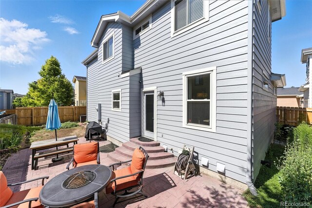 10116 Wyandott Cir, Denver, CO 80260 - back of house featuring a fire pit, a patio area, a fenced backyard, entry steps, and outdoor dining area