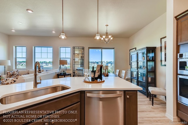 935 W 128th Pl, Westminster, CO 80234 - kitchen featuring stainless steel dishwasher, open floor plan, light countertops, healthy amount of natural light, and recessed lighting
