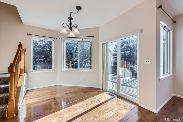 2660 Timberchase Trl, Highlands Ranch, CO 80126 - unfurnished dining area featuring a chandelier, wood-type flooring, stairs, and baseboards