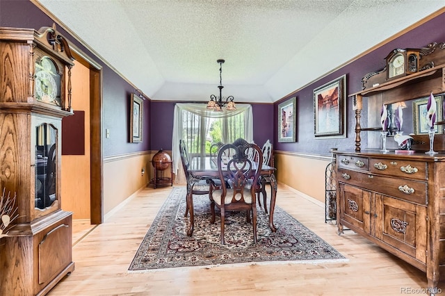 7863 W Friend Dr, Littleton, CO 80128 - dining room featuring a chandelier, light wood-style flooring, a textured ceiling, baseboards, and lofted ceiling