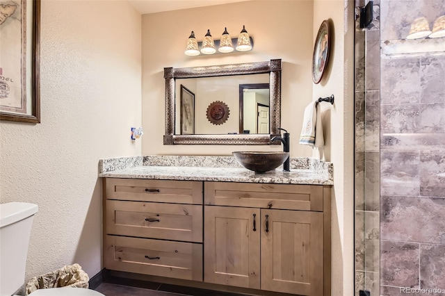 7863 W Friend Dr, Littleton, CO 80128 - bathroom with toilet, vanity, tiled shower, and a textured wall
