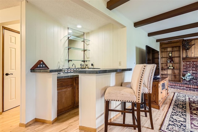 7863 W Friend Dr, Littleton, CO 80128 - indoor wet bar with light wood-style floors, beamed ceiling, and wood walls