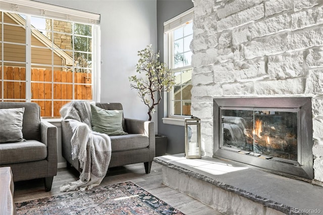 living area with a healthy amount of sunlight, a fireplace, and wood finished floors