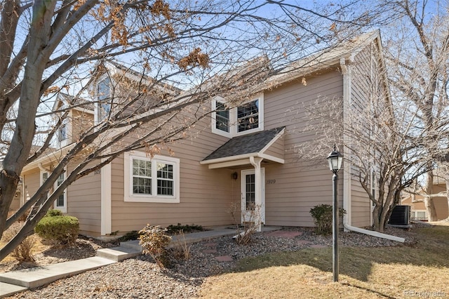 view of front of home with a shingled roof and cooling unit