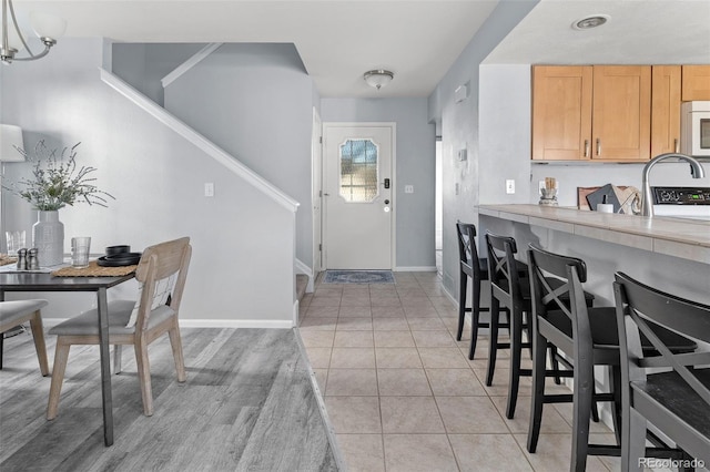 entrance foyer with light tile patterned floors, baseboards, and a chandelier