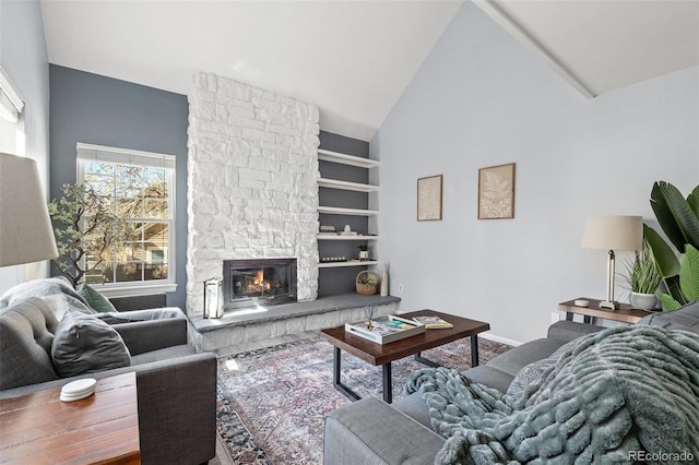 living area with high vaulted ceiling, a fireplace, and baseboards