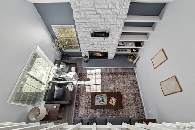 living area featuring a high ceiling and a stone fireplace