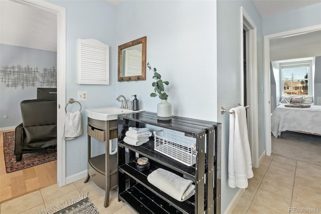 bathroom with baseboards, a sink, ensuite bath, and tile patterned floors