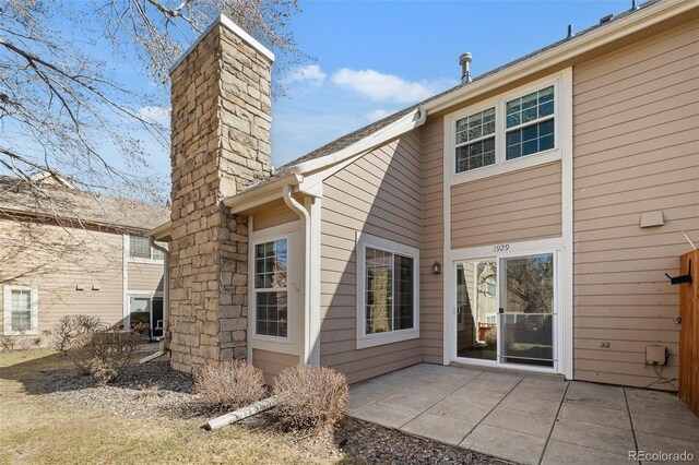 back of house featuring a patio area and a chimney