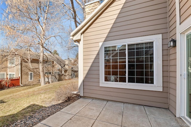 view of side of property featuring a chimney and a lawn