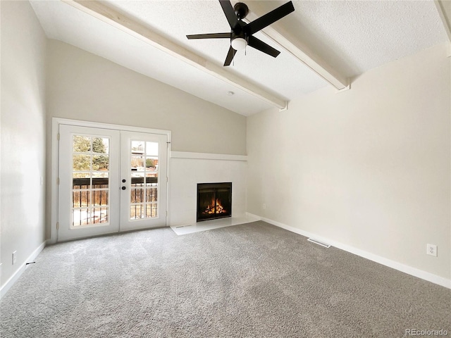 unfurnished living room featuring ceiling fan, beam ceiling, light colored carpet, a tiled fireplace, and french doors