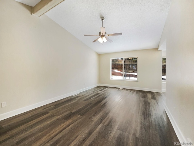 empty room with dark hardwood / wood-style flooring, ceiling fan, vaulted ceiling with beams, and a textured ceiling