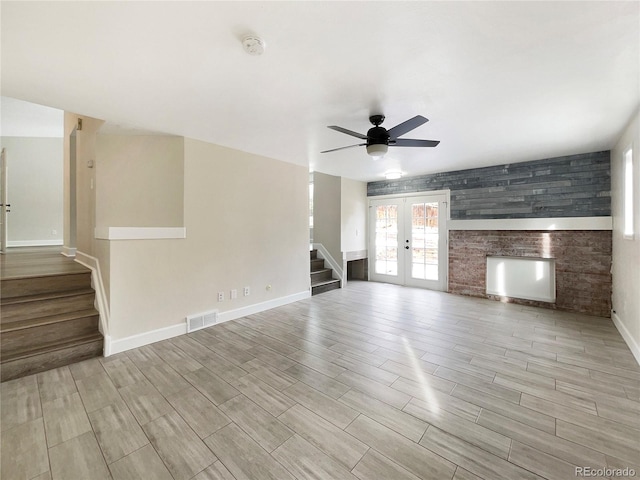 unfurnished living room with ceiling fan and french doors