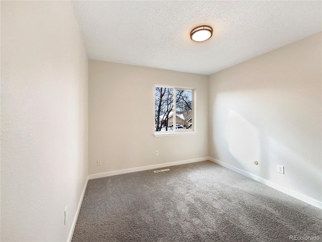 empty room featuring carpet flooring and a textured ceiling