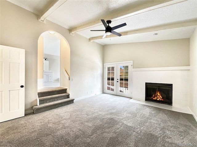 unfurnished living room featuring carpet flooring, a textured ceiling, and french doors