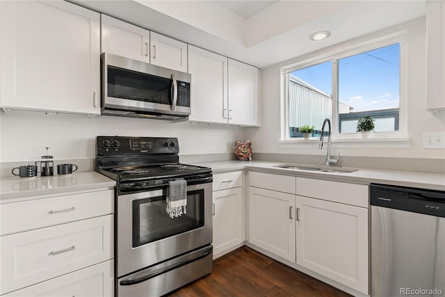 12708 W Virginia Ave, Lakewood, CO 80228 - kitchen featuring stainless steel appliances, a sink, white cabinetry, light countertops, and dark wood-type flooring