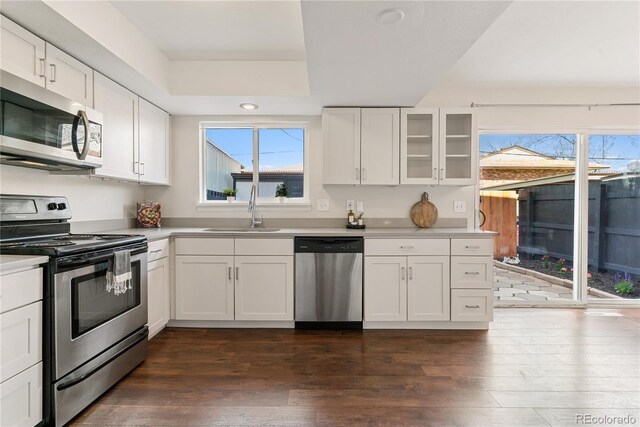 12708 W Virginia Ave, Lakewood, CO 80228 - kitchen with appliances with stainless steel finishes, a sink, dark wood-style floors, white cabinets, and light countertops