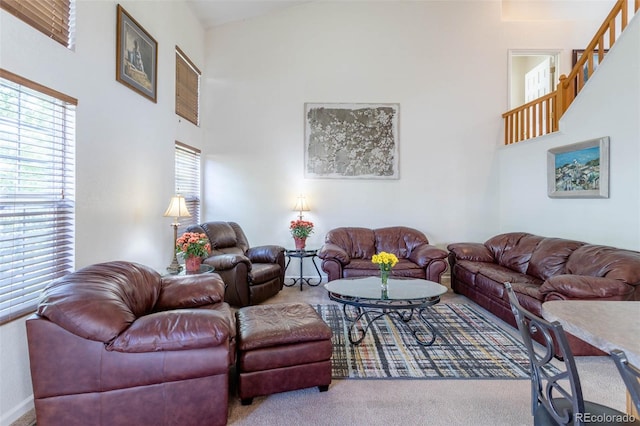 living room featuring carpet and high vaulted ceiling