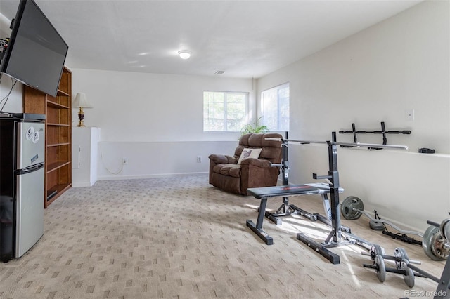 workout room featuring light colored carpet